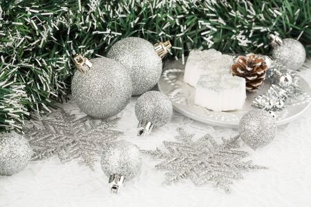 Christmas decoration with garland, balls, candles and snowflakes on the shining net background.の写真素材