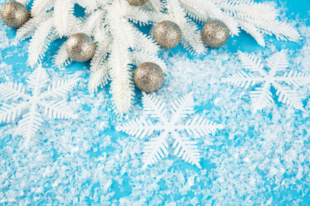 Christmas decoration with balls, snowflakes and white fir tree branch on the artificial snow...