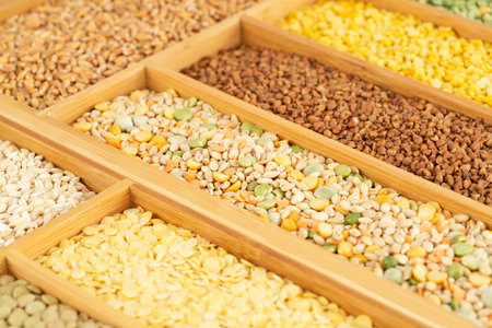 The collection of different groats, lentils, peas, wheat and buckwheat in the wooden box.