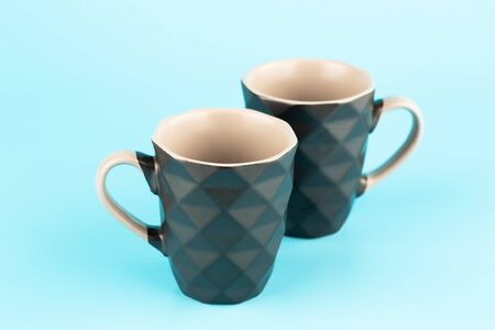 Two brown ceramic cups isolated on blue background.の写真素材