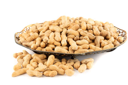 Peanuts in shell in the metallic vintage vase isolated on white background.の写真素材