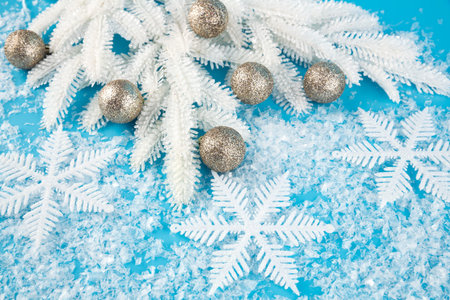 Christmas decoration with balls, snowflakes and white fir tree branch on the artificial snow...