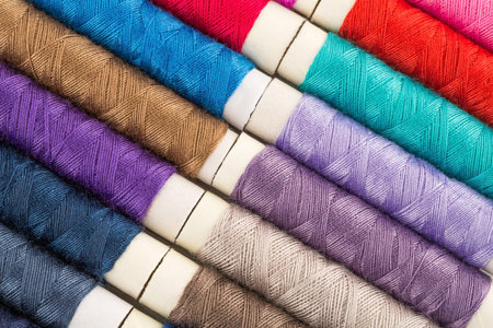 Colorful cotton thread reels close up picture.