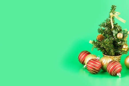 Christmas decoration with fir tree, balls and candle in glass on green background.の写真素材