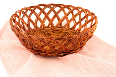 Empty wicker basket and pink towel isolated on white background.の写真素材