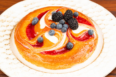 Berries pie with blueberries and blackberries on wooden plate.