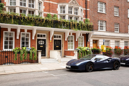 London, United Kingdom - September 23, 2021 - Beautiful blue Ferrari car parked at the old historical building with many plants and flowers.のeditorial素材