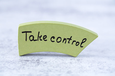 Take control words on the green wooden board on the gray background. Motivation words for success in business.の写真素材
