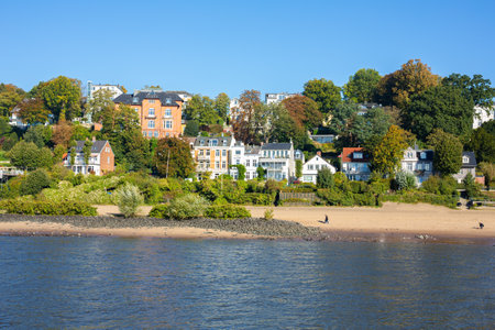 Beautiful riverside landscape in Hamburg, Germany. View from The Elbe river. Luxury houses with green trees at the beach.の写真素材