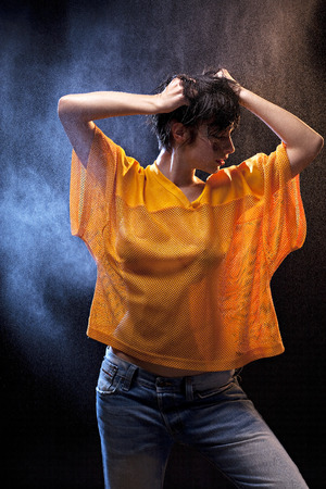 Wet sexy woman with yellow football shirtの写真素材