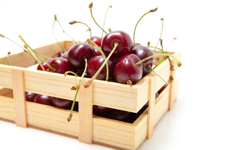Small crate of cherries. Isolate on white background. Studio shot.