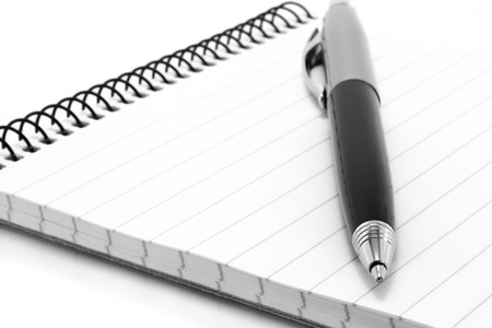 Notepad with ball pen on a white backgroundの写真素材