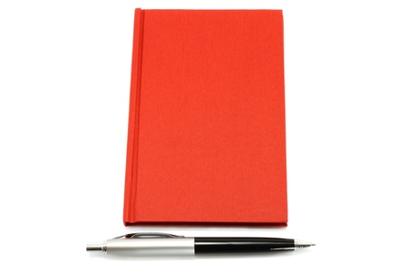 Red notepad with ball pen on a white backgroundの写真素材
