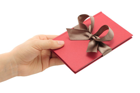 Hand holds notepad with grey bow on white background