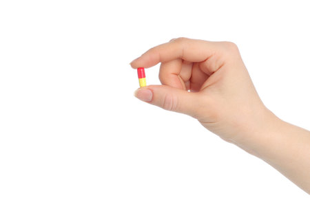 Hand with pill isolated on white background 