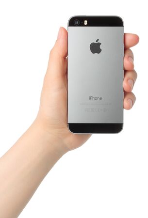 KIEV, UKRAINE - MARCH 7, 2015:Hand holds iPhone 5s Space Gray on white background.iPhone is a line of smartphones designed by Apple Inc.のeditorial素材
