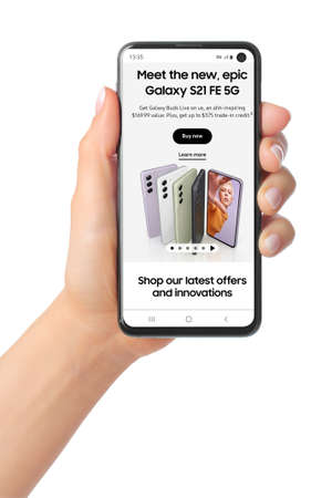 Kiev, Ukraine - January 20, 2022: Hand holds mobile phone with ads of new smart phone Samsung Galaxy S21 FE 5G on its screenのeditorial素材