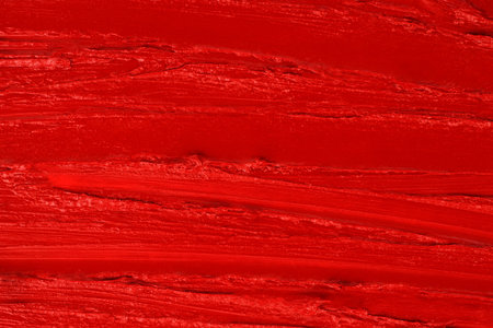 Red lip gloss background with smears, texture background close-up