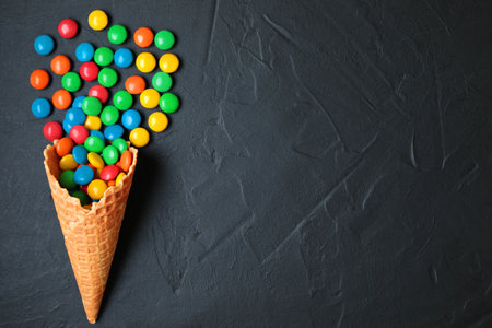 Waffle Cone with Color Candies on black concrete background close-upの写真素材