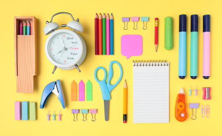 School and office supplies on yellow background, mock-up top view close-up