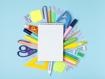 Blank notepad and stationery items on a blue background, template concept, top view close-upの写真素材