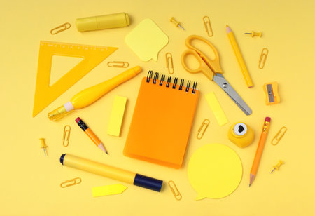 School and office supplies on yellow background, mock-up top view, monochrome concept close-upの写真素材