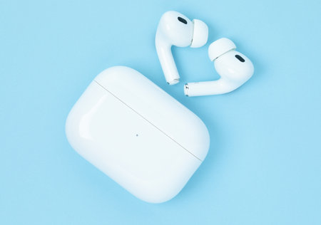 Kiev, Ukraine - June 10, 2023: Headphones Apple Air Pods Pro 2 with Wireless Charging Case on blue background, top view. AirPods are wireless Bluetooth earbuds designed by Apple Inc.のeditorial素材
