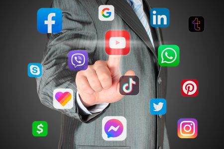 Man pushes virtual social media app icon on a dark background, connection to social media conceptのeditorial素材