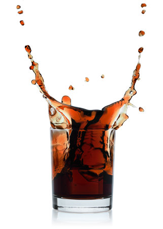 Splash in glass with cola beverage, isolated on a white background, summer beverages conceptの写真素材