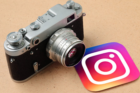 Retro photo camera with Instagram app icon, on old paper background. Instagram is an American photo and video sharing social networking service owned by Meta Platformsのeditorial素材