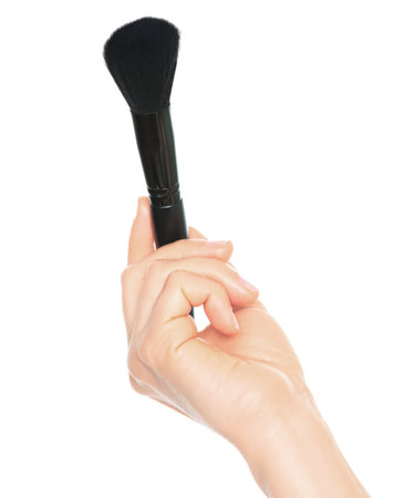 Woman hand holds black cosmetics brush, isolated on a transparent background, cosmetics and visage conceptの写真素材