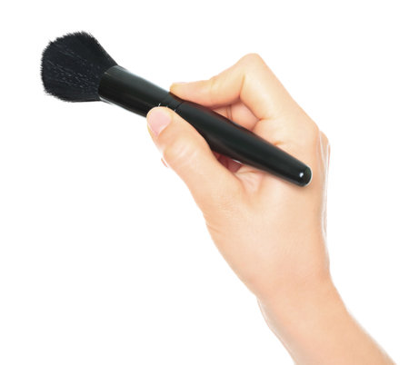 Woman hand holds black cosmetics brush, isolated on a transparent background, cosmetics and visage conceptの写真素材