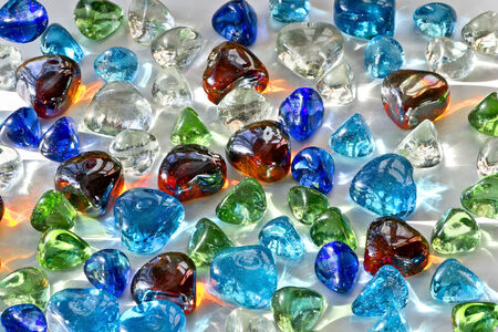 Colorful background of glass hearts and  pebbles another form  Red hearts shine of warm golden colorの写真素材