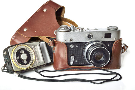 Vintage photo camera in  leather case and exposure meter of the last century on a white background. The history of the development of photographic equipment and technologyの写真素材