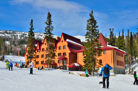 Ski resort Sheregesh, Green mountain, Mountain Shoria, Kemerovo region, Russia - March 19,2017: Beautiful sunny mountain landscape with skiers and snowboarders near the hotel.のeditorial素材