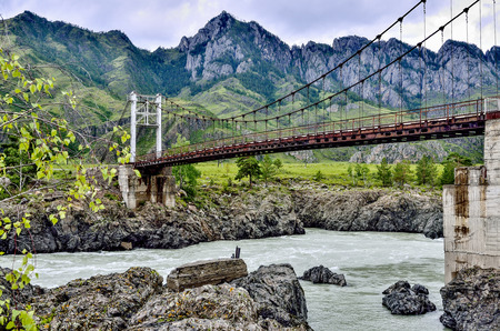 Summer landscape of fast mountain river Katun with Teldykpen rapids and Oroktoy bridge, Altai mountains, Russia. This is the narrowest and deepest place of mountain riverの写真素材