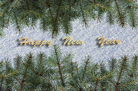 Festive background with green fir tree branches over snow surface and text Happy New Year - greeting card or party invitation templateの写真素材