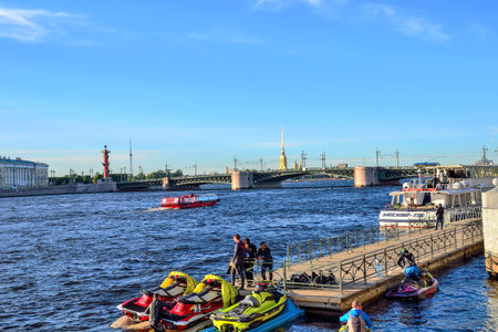 St. Petersburg, Russia - June 13, 2019: Boat trips and excursions for tourists on the Neva river by launch and jet skiing. Young guys on wharf are getting ready to ride scootersのeditorial素材