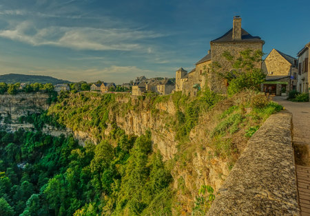 View of the houses at the edge of the canyon in the village of Bozouls in a sunsetのeditorial素材