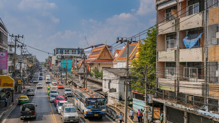 Busy street with a lot of traffic old buildings and a temple under a blue skyのeditorial素材