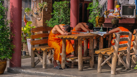 Three young Buddhist monks sleeping on a tableのeditorial素材