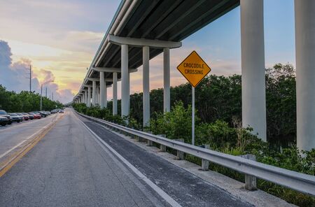 Overseas highway to Key West island, Florida Keys, Florida, USA - July 15, 2018: Bottom view of the Overseas Highway with a warning sign for crocodiles passingのeditorial素材