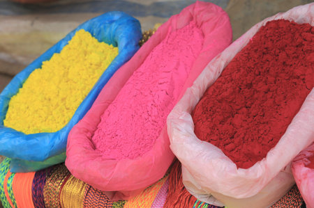 Plastic bags containing colored powders, yellow pink and red, placed over manycolored strings at the exit of the Dakshin Kali hinduist temple, Pharping, Kathmandu, Nepal の写真素材