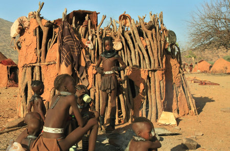 EPUPA, KAOKOLAND/NAMIBIA - OCTOBER 16: Group of Himba boys and girls talk on October 16, 2010 in a seasonal settlement near Epupa, Kunene region, Kaokoland, Namibia.のeditorial素材