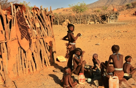 EPUPA, KAOKOLAND/NAMIBIA - OCTOBER 16: Young Himbas sit and talk on October 16, 2010 in a seasonal settlement near Epupa, Kunene region, Kaokoland, Namibia.のeditorial素材