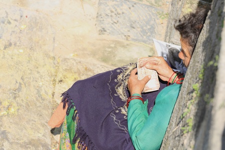 DEOPATAN, KATHMANDU, NEPAL - OCTOBER 5  Local business woman sitting by Bagmati river counts her...