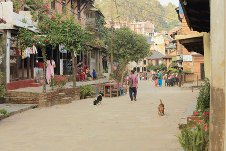 BANDIPUR, NEPAL - OCTOBER 6: Tourists and locals walk and sit along the cobblestone pedestrian central street at sundown while the cafes alongside begin to open on October 6, 2012 in Bandipur-Tanahu District-Gandaki Zone-Nepal.のeditorial素材