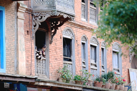 BANDIPUR, NEPAL - OCTOBER 7  Mother and daughter watch the people going up and down the street from their home s window in the evening on October 7, 2012 in Bandipur-Tanahu district-Gandaki zone-Nepalのeditorial素材