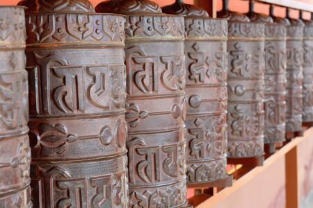 Metallic buddhist prayer wheels on the outer wall of the 1978 ad-V.V.Khenchen Thrangpu Rinpoche founded Thrangu Tashi Yangtse Monastery. Namo Buddha-Kavrepalanchok distr.-Bagmati zone-Nepal.のeditorial素材