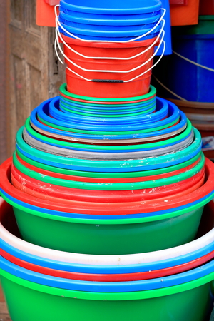 Pile of colorist plastic pails and buckets set for sale at the entrance of a shop in a street of the old city area. Panauti-Kavrepalanchok dstr.-Bagmati zone-Nepal.の写真素材